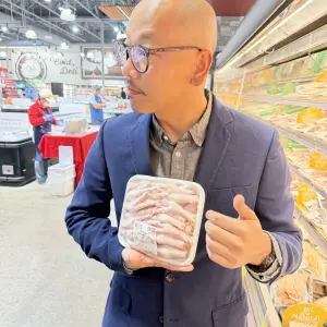Yijia Lu, Director of Merchandising showing Chicken Feet as a delicacy